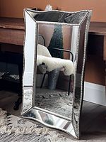 Front angled view of the scalloped edge mirror with metro beaded frame showing reflective quality and shape.