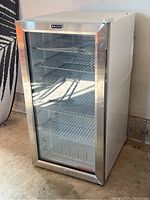 Front view of the Whynter beverage fridge showing glass door with stainless steel trim and four wire shelves inside.