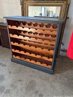 Full front view of a solid wood wine storage cabinet with dark grey painted exterior and stained wood interior. Shows five shelves with slots for wine bottles.