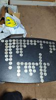 View of 83 Kennedy half dollar coins laid out on a black table showing all coins in the lot.