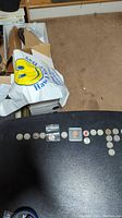 Overview of all coins laid out on a table, showing a row of quarters and other smaller coins alongside bags and holders.
