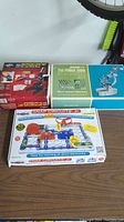 Two microscopes and two Snap Circuits kits in original boxes arranged on a surface