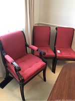 Two upholstered armchairs and one armless side chair grouped near a window