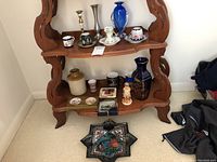 Full view of decor items on shelves and star-shaped pottery dish on floor