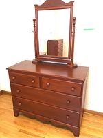 Front view of the dresser showing the solid wood top, 4 drawers with wooden knobs, and a large washstand style mirror mounted on turned wood posts.