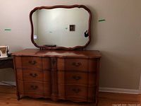 Front view of the solid wood dresser with large attached mirror and curved drawer fronts