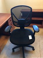 Front view showing mesh back, padded seat, and armrests on black wheeled base.