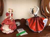 Photo showing both Royal Doulton figurines, Top o' the Hill and Karen, side by side on a shelf
