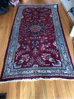 Full view of the ornate throw runner rug on wood floor showing overall pattern and size