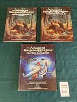 Three Dungeons & Dragons books: two Monster Manual II and one Player's Handbook, all with illustrated covers.
