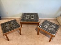 Three tables arranged on floor showing coffee table in center and two end tables on either side