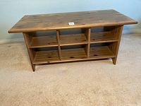 Front view of wood coffee table showing multiple shelves underneath top surface.