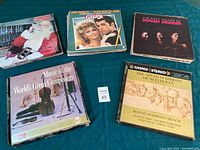 Photo showing four vinyl records with visible album covers including Grease soundtrack, The Main Voices of Miriam Makeba, The Ninth Symphony of Beethoven, and Music of the World's Great Composers.