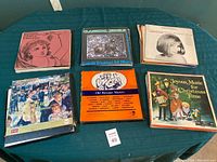 Photo showing multiple vinyl record albums including Catelli Trinidad All Stars, Old Baroque Masters, and Joyous Music for Christmas Time with a stack of records on green table.