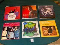 Photo showing 6 vinyl record album covers laid out: Stompin' at the Savoy, Belafonte Calypso, a classical piano album, Nina & Frederik with Louis Armstrong, Scott Joplin Ragtime albums.