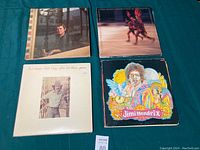 Four vinyl records shown: Paul Simon, a record with red cover showing dancers, Paul Simon Still Crazy After All These Years, and Jimi Hendrix.