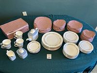 Full display of the Royal Doulton dinner and tea set laid out on a table with protective quilted bags in background.