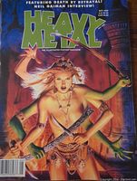 Close-up of the front cover showing a fantasy warrior woman with swords, tribal jewelry and attire, the title 'Heavy Metal' in large green letters, May 1998 issue date, and price information.