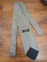 Handmade silk Hugo Boss tie laid flat showing the label inside and the leather tip on the reverse side.