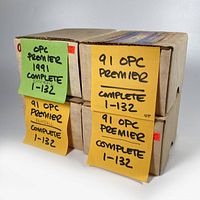 Four cardboard boxes labeled as 1991 OPC Premier complete baseball card sets numbered 1 to 132.