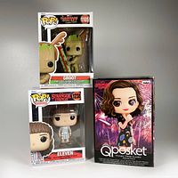 Three figures in original packaging: Groot from Guardians of the Galaxy Holiday Special #1105 Funko Pop, Stranger Things Eleven #1238 Funko Pop, and Qposket Stranger Things Eleven vol. 2 box.