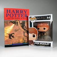 Photo of Harry Potter and the Goblet of Fire paperback and Funko Pop Ron Weasley boxed figurine side by side.