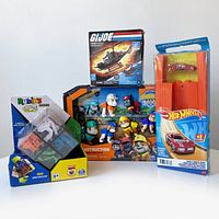 Photo showing all four new in box toys including G.I. JOE Cobra F.A.N.G set, Hot Wheels car and track, Paw Patrol Rubble & Crew set, and Rubik's Perplexus Hybrid puzzle.