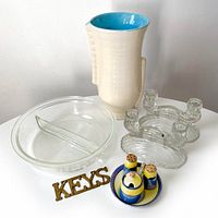 Photo showing all six items: pottery vase, Pyrex divided dish, two clear depression glass candle holders, lustreware condiment set, and brass key hooks arranged on white surface against white wall