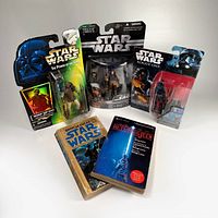Photo of the lot showing two vintage paperback Star Wars books and three carded Star Wars action figures from various lines.