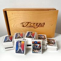 Wooden Jays box with sliding lid behind 36 stacks of baseball cards in plastic sleeves.