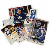 Lot items arranged showing autographed photos, fact book, schedule, and ticket stub together.