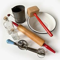 7-piece vintage kitchen utensil lot including rolling pin, meat mallet, hand-crank egg beater, flour sifter, enamelware bowl, and two glass bottles.