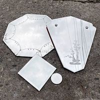 Top-down view of four vintage mirrors including bonsai wall-hanger, octagonal mirror, and two smaller display mirrors (square and round), all lying on concrete. Shows general condition and surface wear.