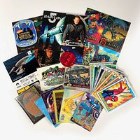 Top view of the cards and promotional sheets spread out showing various franchises including Marvel, Star Trek, Babylon 5, Magic: the Gathering, sailormoon, and Batman.