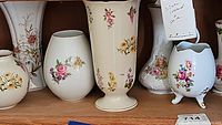 Shelf with six china vases, floral designs, different shapes and sizes