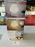 Front view of the stacked boxes containing three brand new ShroomLum small LED lamps, each with an image of the lamp and product details.