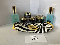 Full lot display showing six Elizabeth Grant skincare products and a cosmetics bag on a gray table against a gray backdrop.