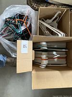 Three containers holding various clothing hangers including plastic and metal types.