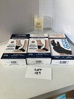 Four boxed items including two Copper Fit Arch Relief Orthotic Supports, one Copper Fit Hand Relief Support, and a Lilac & Spruce Sleepy-Toes Foot Balm stick.