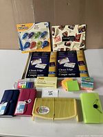 Full view of lot including two expandable file folders, BIC Wite-Out correction tape, Post-it notes, business card making set, and two ACCO Clean Edge business card paper packs.