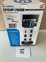 Front view of the SpinPower power bar tower original box displaying the product image, capacity to charge 14 devices at once, quick charging, and surge protection features.