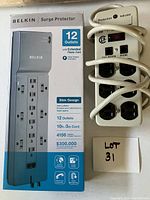 Vintage power bar with 6 outlets and EMI protection indicator, off-white, coiled cord, alongside the boxed Belkin surge protector.