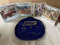 All 4 puzzle boxes and blue puzzle assembly system in plastic wrap