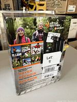 Box of a Little Hotties Dryer showing front image with people outdoors and product name in English, French and Spanish.