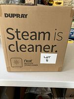 Original cardboard box of Dupray Neat multi-use steam cleaner with branding and lot sticker.