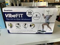 Photo of the Quantum VibeFit box showing 99 speeds, 9 programs, and targeted workout areas (arms, buttocks, legs, abs).