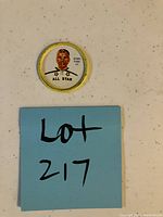 Photo showing the vintage Shirriff Jacques Plante hockey coin with a blue sticky note labeled Lot 217.