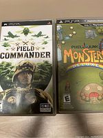 Photo of two PSP game cases: Field Commander and Pixels Junk Monsters Deluxe, front covers visible.