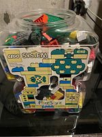 Large plastic container with vintage LEGO System 4148 label filled with various colored LEGO blocks