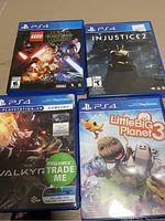 Four boxed PS4 games: LEGO Star Wars, Injustice 2, Valkyrie, and Little Big Planet 3.